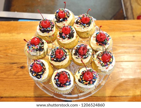 Platter of vegan vanilla sundae cupcakes with a cherry on top