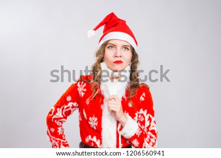 Funny girl in wearing xmas santa costume and beard over white background. Holidays, joke and people concept