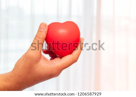 Man's hand giving red heart. closeup. The photo shows the principle of caring and good heath. 