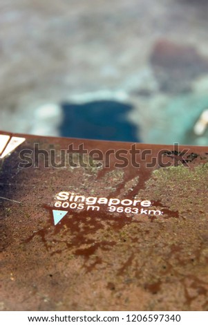 Little signage on Table Mountain showing distance to Singapore