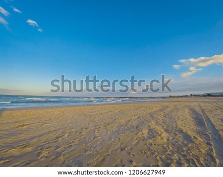 A photo of the San Antonio beach by the Mediterranean Sea close to mouth of the Juquer river at sunset. The photo was taken in the seaside coastal town of Cullera, in Valencia, Spain, Europe.