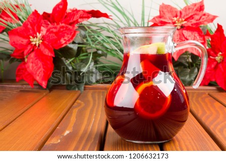 Red wine sangria or punch with fruits on wood table background. Copy space for text area.