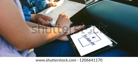 Young couple comparing a paper map and a gps navigator on the tablet sitting in the car. Customizable tablet screen