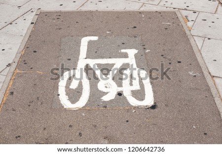 A cute bicycle symbol imprint on an urban concrete pavement.