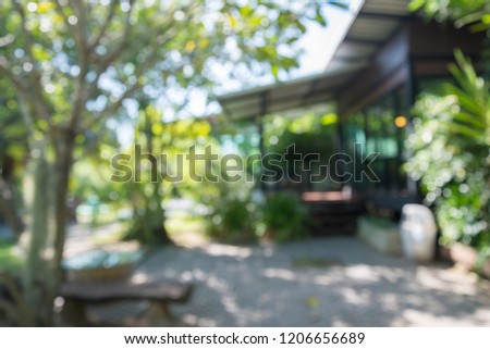 Abstract blurred bokeh outdoor coffee shop, coffeehouse or cafe in green nature garden on day time background.