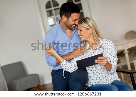 Lovely young couple with digital tablet in the room