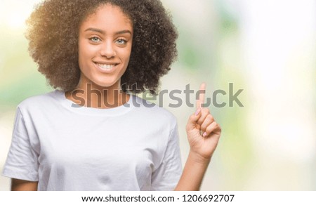 Young afro american woman over isolated background showing and pointing up with finger number one while smiling confident and happy.