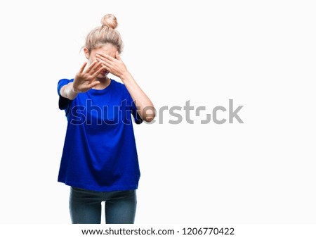 Young beautiful blonde and blue eyes woman wearing blue t-shirt over isolated background covering eyes with hands and doing stop gesture with sad and fear expression. Embarrassed and negative concept.