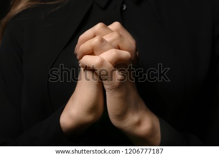 Hands of young praying woman, closeup