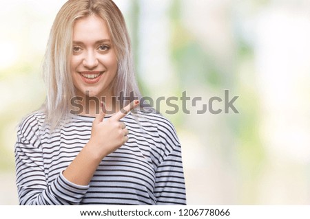 Young blonde woman over isolated background cheerful with a smile of face pointing with hand and finger up to the side with happy and natural expression on face looking at the camera.