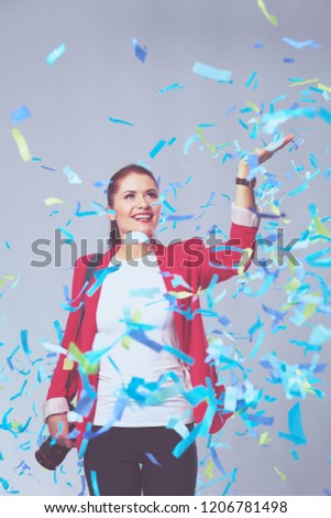 Beautiful happy woman with camera at celebration party with confetti . Birthday or New Year eve celebrating concept