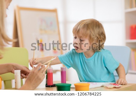 little cute child boy painting pictures in art studio