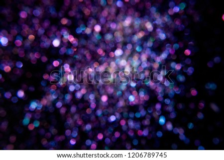 Glitter texture on a dark background, close-up. Bright magic effect. Perfect for party invitation or wallpaper.