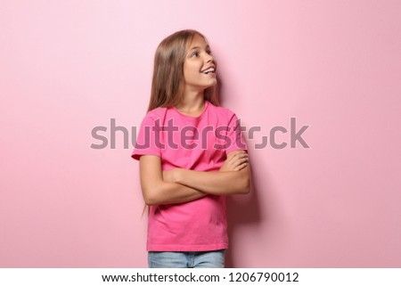 Smiling little girl in t-shirt on color background