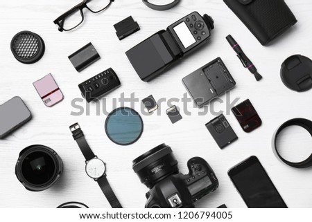 Flat lay composition with equipment for professional photographer on wooden background