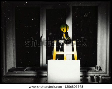 Yellow lamp on the window sill by the window of the starry night sky