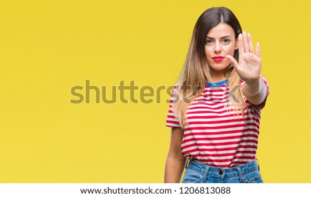 Young beautiful woman casual look over isolated background doing stop sing with palm of the hand. Warning expression with negative and serious gesture on the face.