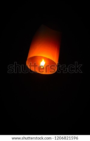 Sky lanterns is floating in dark sky as hot-air balloons in special day of Thai region.
