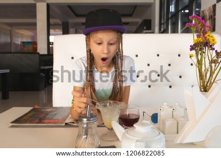Outraged little girl holding empty glass