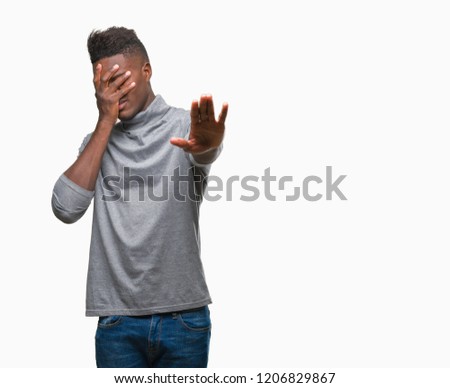 Young african american man over isolated background covering eyes with hands and doing stop gesture with sad and fear expression. Embarrassed and negative concept.