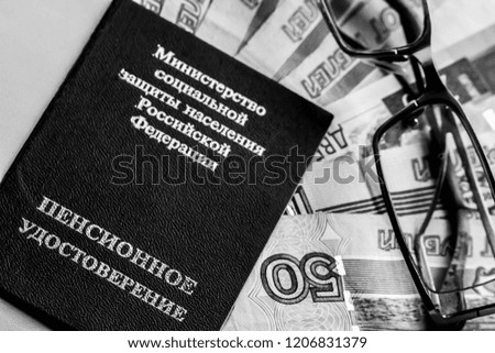 Russian pension certificate, glasses and russian rubles (banknotes). Russian translation - Ministry of Social Protection of Population of Russian Federation. Pension Certificate.