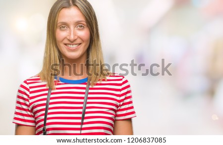 Young beautiful woman taking pictures using vintage photo camera over isolated background with a happy and cool smile on face. Lucky person.