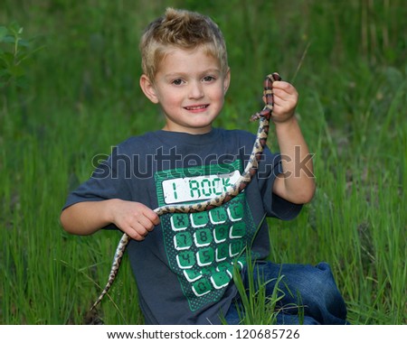 Boy catching wild animals, holding a wild snake - Red Milk Snake, Lampropeltis triangulum syspila