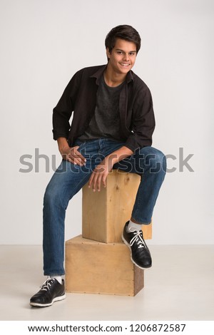 Fashion shot: handsome young man wearing jeans; shirt and sneakers