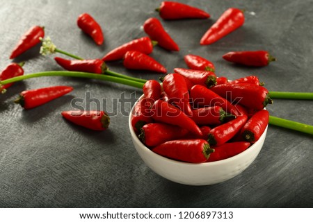 Fresh spicy red peppers on a rustic woode background,