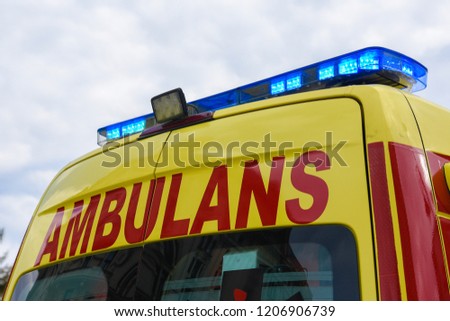 Yellow Ambulance Car with blue neon warning lights. Royalty-Free Stock Photo #1206906739