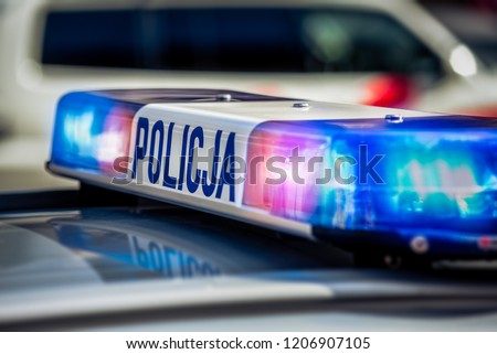 Police car on patrol with red and blue lights and sign.  Royalty-Free Stock Photo #1206907105