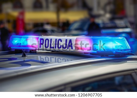 Police car on patrol with red and blue lights and sign.  Royalty-Free Stock Photo #1206907705