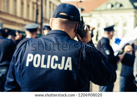 Police sign/logo on the back of the police uniform. Royalty-Free Stock Photo #1206908020
