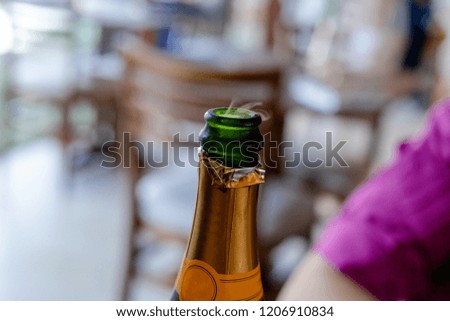 Closeup view of one new open full champagne wive sweet or dry drink green glass bottle with beautiful white smoke for celebration christmas or new year in studio on black background, square picture