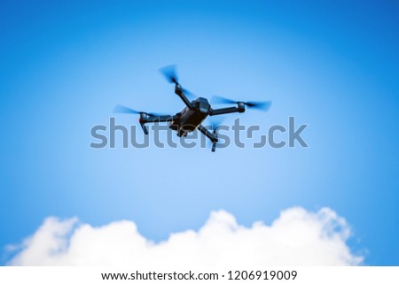 Quadrocopter for shooting video in a blue sky with white clouds