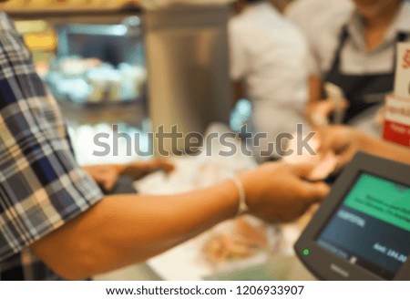 Customer paying for their order with a credit card in a bakery shop.