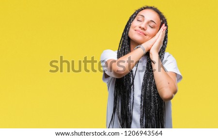 Young braided hair african american girl over isolated background sleeping tired dreaming and posing with hands together while smiling with closed eyes.