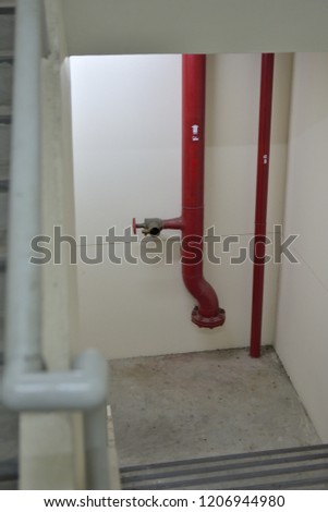 A fire hydrant pipeline and valve located in a fire exit stairway in a car parking building.