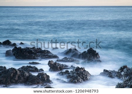 Water with rock nature photo with long exposure fog effect abstract color ocean background 
