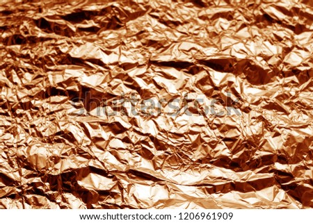 Metal foil texture in orange tone. Abstract background and texture for design.