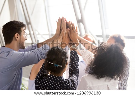 Diverse business team associates office workers group giving high five together as concept of coaching, teamwork involvement, engaging in teambuilding, motivated by unity, good corporate relations Royalty-Free Stock Photo #1206996130