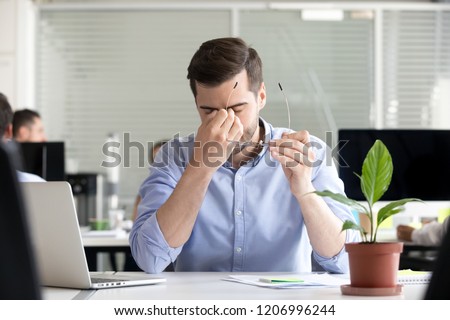 Tired businessman taking off glasses lost productivity after office work laptop use to relieve dry irritated eyes feeling fatigue tension or strain, chronic computer syndrome, bad weak vision problem Royalty-Free Stock Photo #1206996244