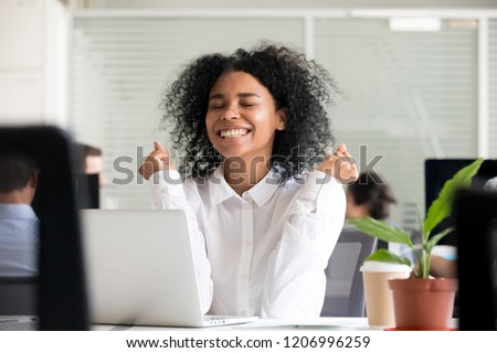 Excited african office worker student receiving good news in email on laptop, motivated happy black female employee getting promoted or rewarded celebrating great result achievement win opportunity Royalty-Free Stock Photo #1206996259
