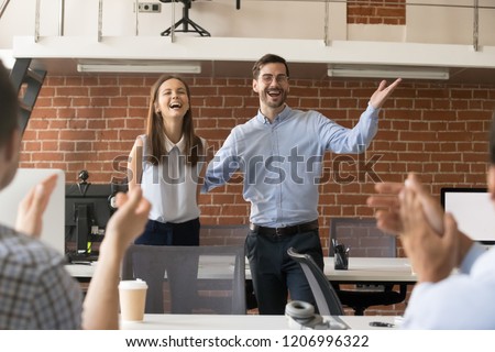 Excited company boss or team leader introducing new employee to colleagues in office welcoming hired newcomer member congratulating with promotion applauding celebrating reward, supporting coworker Royalty-Free Stock Photo #1206996322