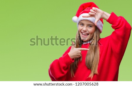 Young beautiful girl wearing christmas hat over isolated background smiling making frame with hands and fingers with happy face. Creativity and photography concept.