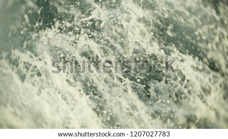 engine propellers churn the water in waves and wakes. The spray of water from the ship's propellers in the open sea, close-up