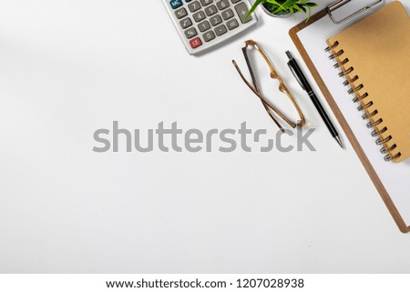 View from above.eye glasses,pen,notebook,calculator, and cup of coffee on white office desk with copy space.