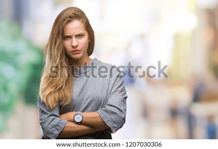 Young beautiful blonde woman over isolated background skeptic and nervous, disapproving expression on face with crossed arms. Negative person.