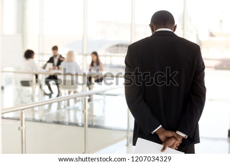 Nervous African American employee standing in hallway waiting to enter business meeting, worried black presenter anxious about making presentation for colleagues or workers in boardroom Royalty-Free Stock Photo #1207034329