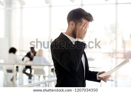 Stressed man sweat using wipe worry about business interview, frustrated male employee reading papers prepare for hiring at corporation, nervous worker review cv before talk with recruiters in office Royalty-Free Stock Photo #1207034350